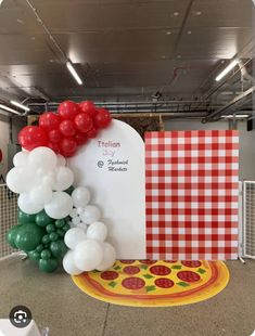 a pizza themed birthday party with balloons and table cloths on the floor in front of it