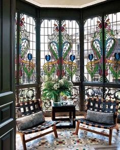 an image of a living room with stained glass windows on the wall and furniture in the middle