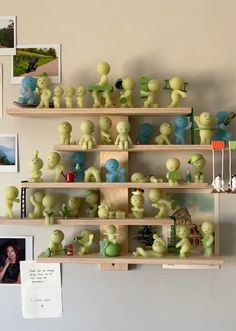 there are many small green figurines on the shelves in this room, all stacked together