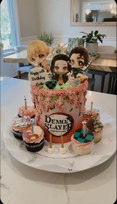 a decorated birthday cake with cupcakes and candles