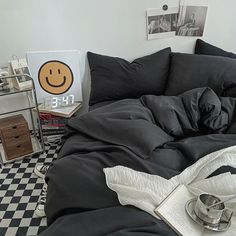 an unmade bed with black and white checkered flooring