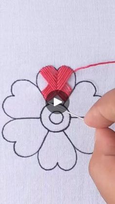 someone is stitching a heart on a t - shirt