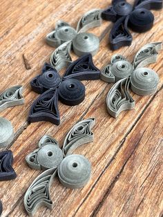 several different types of buttons on a wooden surface with pins in the shape of birds