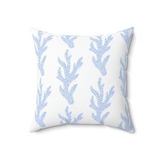 a blue and white pillow on a white background with an image of a plant pattern