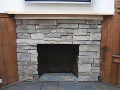 a stone fireplace with wood paneling around it