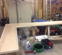 an unfinished workbench in a garage with tools and other items on the floor