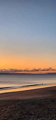 two people walking on the beach at sunset with an ocean view in the back ground