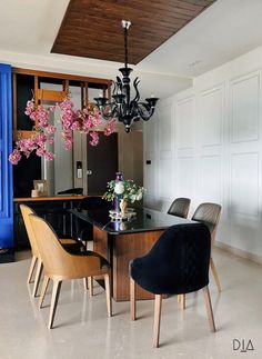 a dining room table with chairs and a chandelier hanging from it's ceiling