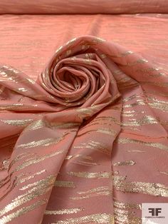 a pink and gold fabric with metallic stripes