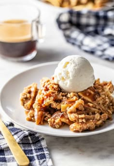 a close up of a plate of food with ice cream on top and coffee in the background