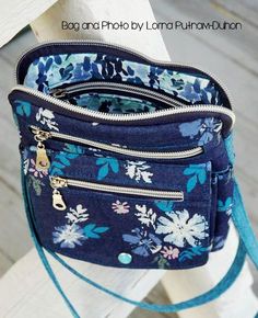 a blue floral purse sitting on top of a wooden bench