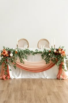 an image of a table setting with flowers and greenery on the tablescloths