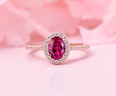 a close up of a ring with a pink stone in the center and diamonds around it