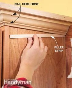 a person measuring the width of a cabinet door