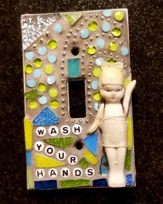 a glass and metal light switch cover with a girl holding a handwritten message on it