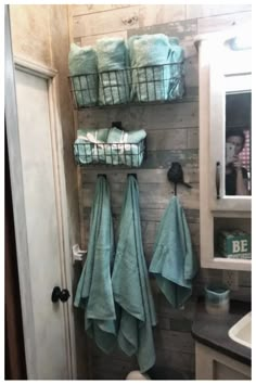 a bathroom with towels hanging on the wall next to a toilet and sink in it