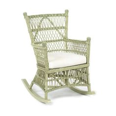 a wicker rocking chair with white cushions