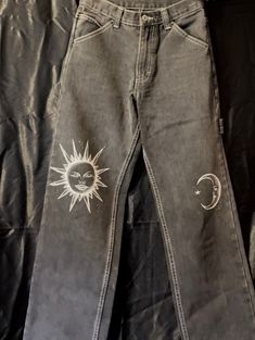 a pair of jeans with sun and moon patches on them