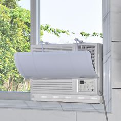 an air conditioner sitting on top of a window sill next to a window