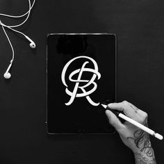 a person writing on a tablet with headphones and earbuds next to it