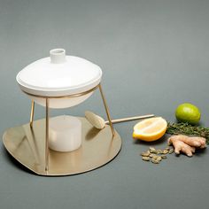 a citrus juicer sitting on top of a table next to sliced fruit and vegetables