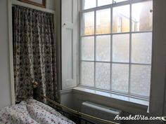 a bed sitting under a window next to a radiator in front of a window