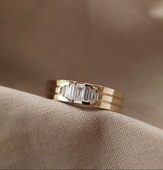 a gold wedding band with three baguettes on top and two diamonds in the middle