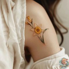 a woman's stomach with yellow flowers on the side and behind her is a white shirt