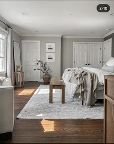 a bedroom with white walls and wood floors