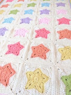 a crocheted blanket with multicolored stars on it