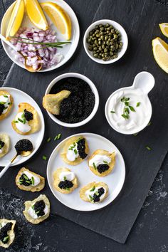 several small plates with food on them next to lemon wedges and other foodstuffs