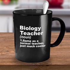 a black coffee mug with the words biology teacher on it and a toothbrush inside