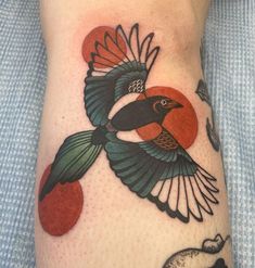 a bird with an apple on it's leg is shown in this tattoo design