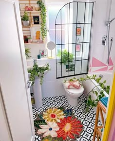 a bathroom with an open door leading to a toilet and shower area that has flowers on the floor