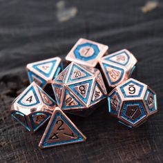 blue and silver metal dice sitting on top of a wooden table