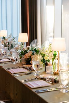 A high end table setting for a corporate event in Dallas, Texas. In addition to cutlery and napkins, the table is also adorned with floral centerpieces and small lamps. Corporate Event Branding, High End Branding, Event Branding, Branding Photography