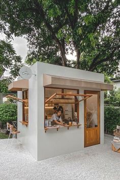 two people sitting at a table in a small white building