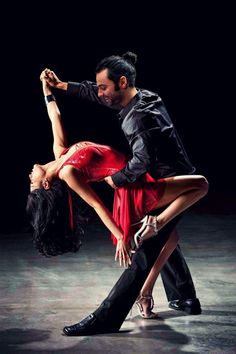 a man and woman are dancing together in an artistic pose with their arms around each other