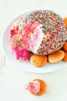 a white plate topped with donuts covered in sprinkles and frosting