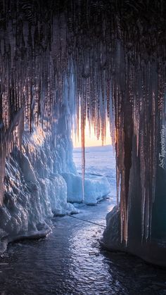 an ice cave with icicles hanging from the ceiling and water running down it's sides