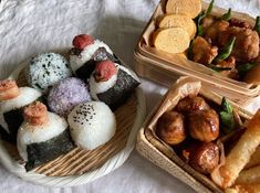 there are many different types of sushi on the plate and in baskets next to each other