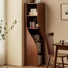 a room with a table and chair next to a book shelf filled with books on top of it