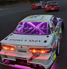 a white car with neon lights on it's hood