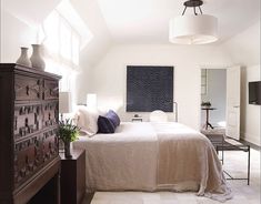 a bedroom with a large bed and white walls