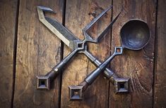 four old kitchen utensils are arranged on a wooden surface with spoons and ladles