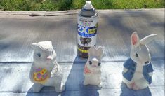 three plastic rabbits sitting on the ground next to a bottle of deodorant