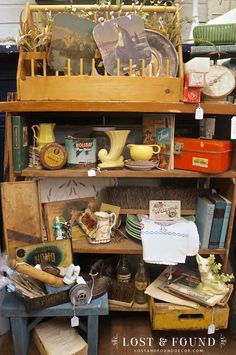 an old wooden shelf filled with lots of antiques and other items on top of it