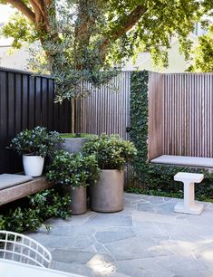 two cement planters sitting next to each other in front of a fenced area