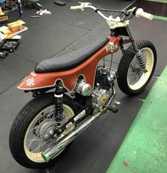 a motorcycle is parked in a garage with other tools on the floor and around it