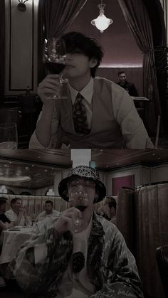 a man in a suit and tie drinking from a wine glass while sitting at a table